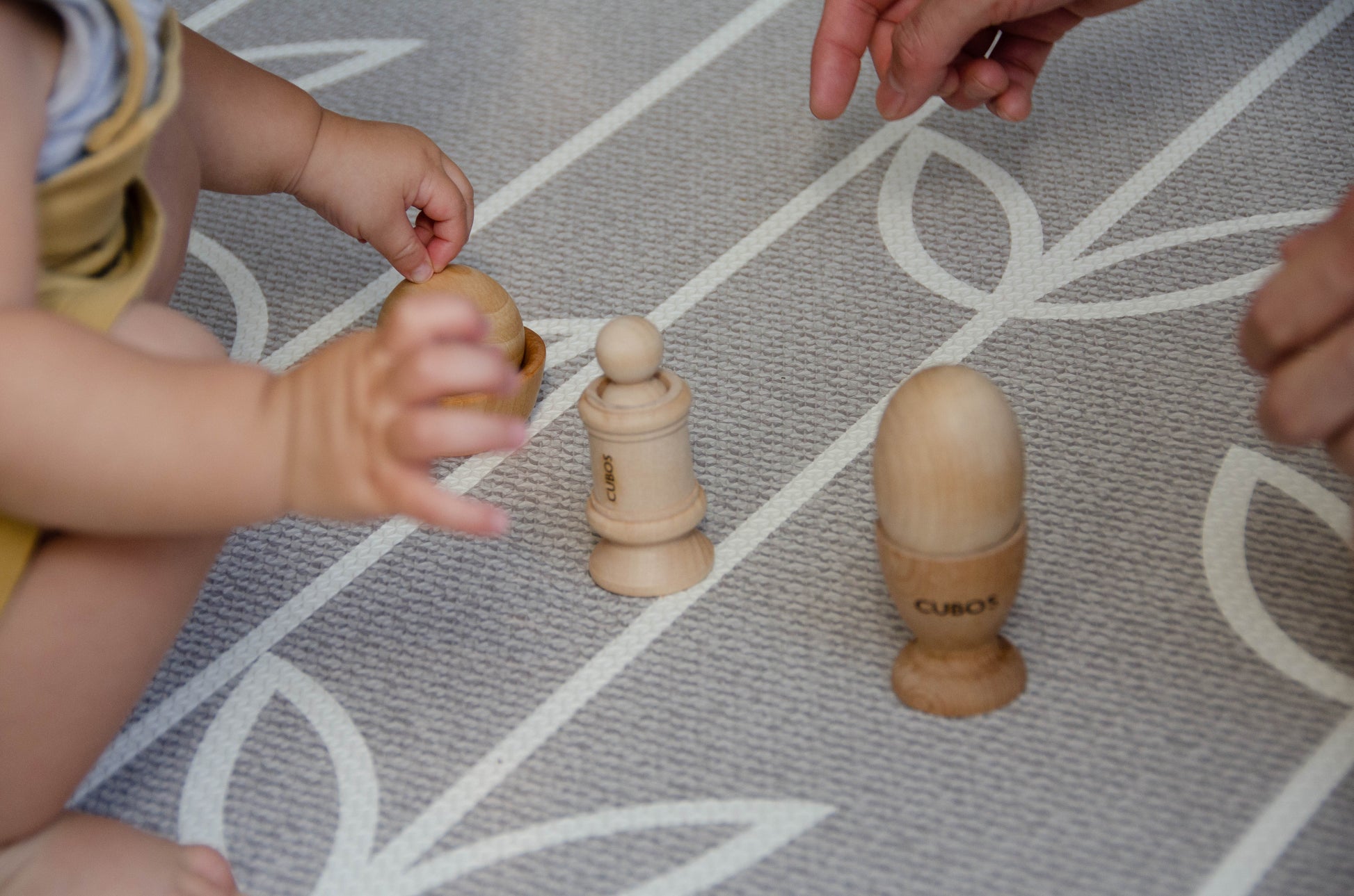 Baby engaging in playtime with the Cubos Ball Bowl, Peg & Egg Cup set, exploring and interacting with the different elements for fun and learning.