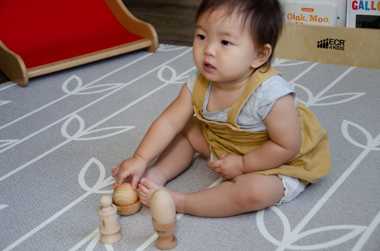 Baby happily playing with the Ball Bowl from the Cubos Ball Bowl Peg & Egg Cup set, enjoying the tactile experience and exploring its entertaining features."