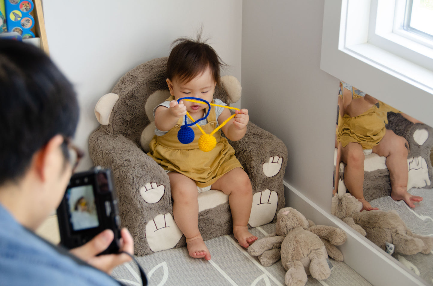 Baby girl happily playing with yarn balls, exploring their textures and enjoying the sensory experience during playtime.
