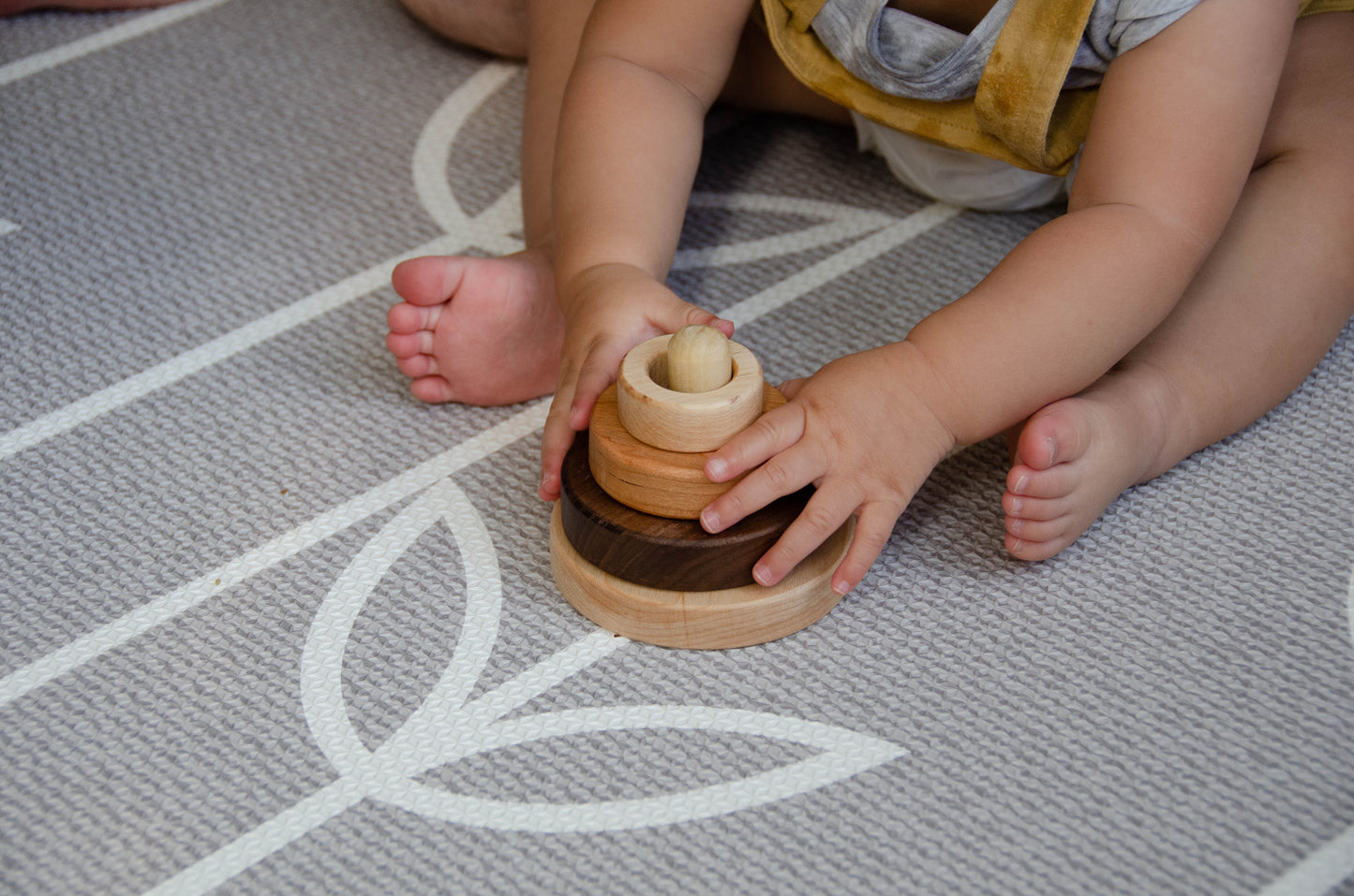 Adorable infant successfully stacks various sizes on CUBOS 3 different size rings stacker