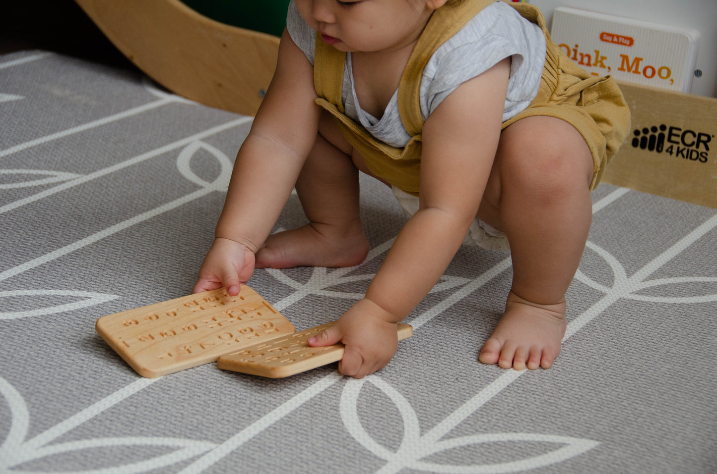 Adorable little girl enthusiastically picking up both iDoddle toys, eager to engage in double the fun and creativity. With her tiny hands full of wooden pens, she is all set for a delightful playtime experience, where she can explore and learn through drawing, tracing, and writing to her heart's content.