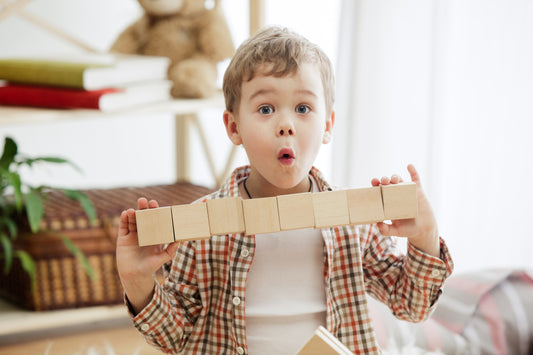 Little boy playing wooden blocks