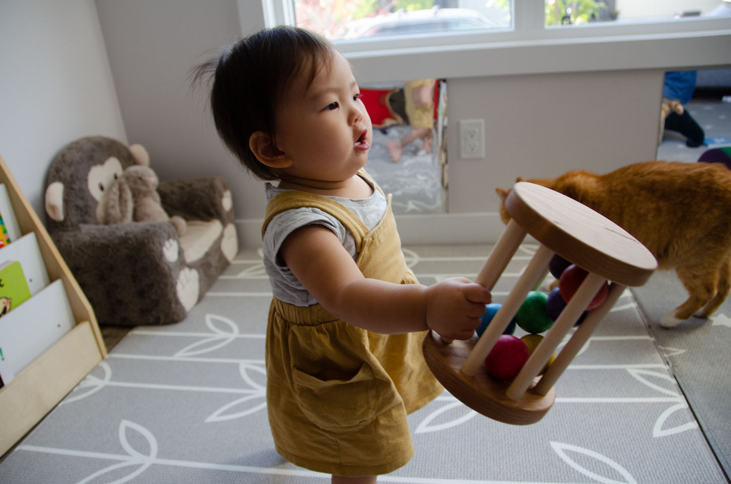 The little girl is happily picking up the Qualitmonti - Color Ball Cylinder toy. With enthusiasm and curiosity, she explores the colorful balls and the cylinder, captivated by the tactile and sensory experience the toy offers. As she engages with the different elements, she enhances her fine motor skills, hand-eye coordination, and color recognition. This interactive playtime encourages her learning and creativity while providing endless fun and exploration.