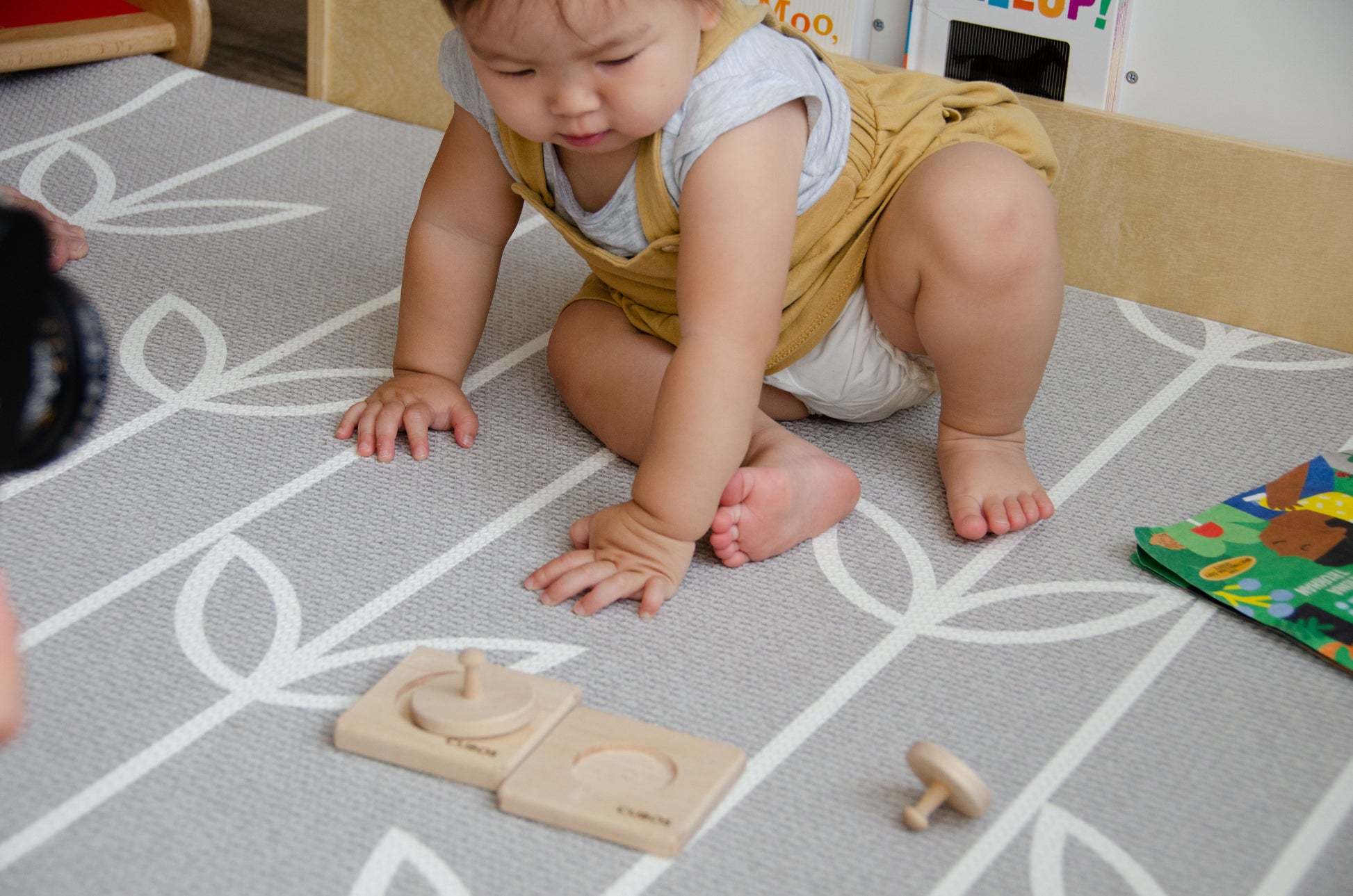 Baby enthusiastically playing with the Cubos 2 Different Size Circle Puzzle, crafted from hardwood with its natural wooden color, exploring and solving the puzzle with keen interest and focus.
