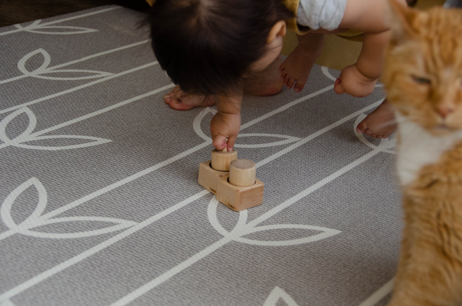 The baby girl is thoroughly enjoying her playtime with Cubos Pincer & Palmer Block. With her tiny hands, she skillfully manipulates the blocks, using the pincer grip to grasp and place them. This interactive and tactile play enhances her fine motor skills, hand-eye coordination, and cognitive development as she explores the different shapes and builds various structures. Her joyful engagement with the educational toy fosters early learning and creativity, making playtime an enriching experience for her.