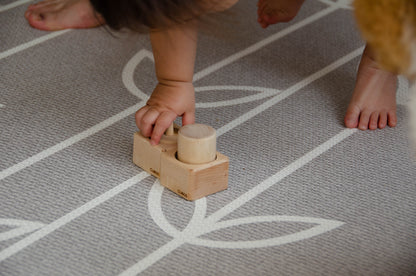 The baby girl is thoroughly enjoying her playtime with Cubos Pincer & Palmer Block. With her tiny hands, she skillfully manipulates the blocks, using the pincer grip to grasp and place them. This interactive and tactile play enhances her fine motor skills, hand-eye coordination, and cognitive development as she explores the different shapes and builds various structures. Her joyful engagement with the educational toy fosters early learning and creativity, making playtime an enriching experience for her.