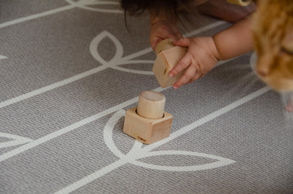 The baby girl is thoroughly enjoying her playtime with Cubos Pincer & Palmer Block. With her tiny hands, she skillfully manipulates the blocks, using the pincer grip to grasp and place them. This interactive and tactile play enhances her fine motor skills, hand-eye coordination, and cognitive development as she explores the different shapes and builds various structures. Her joyful engagement with the educational toy fosters early learning and creativity, making playtime an enriching experience for her.