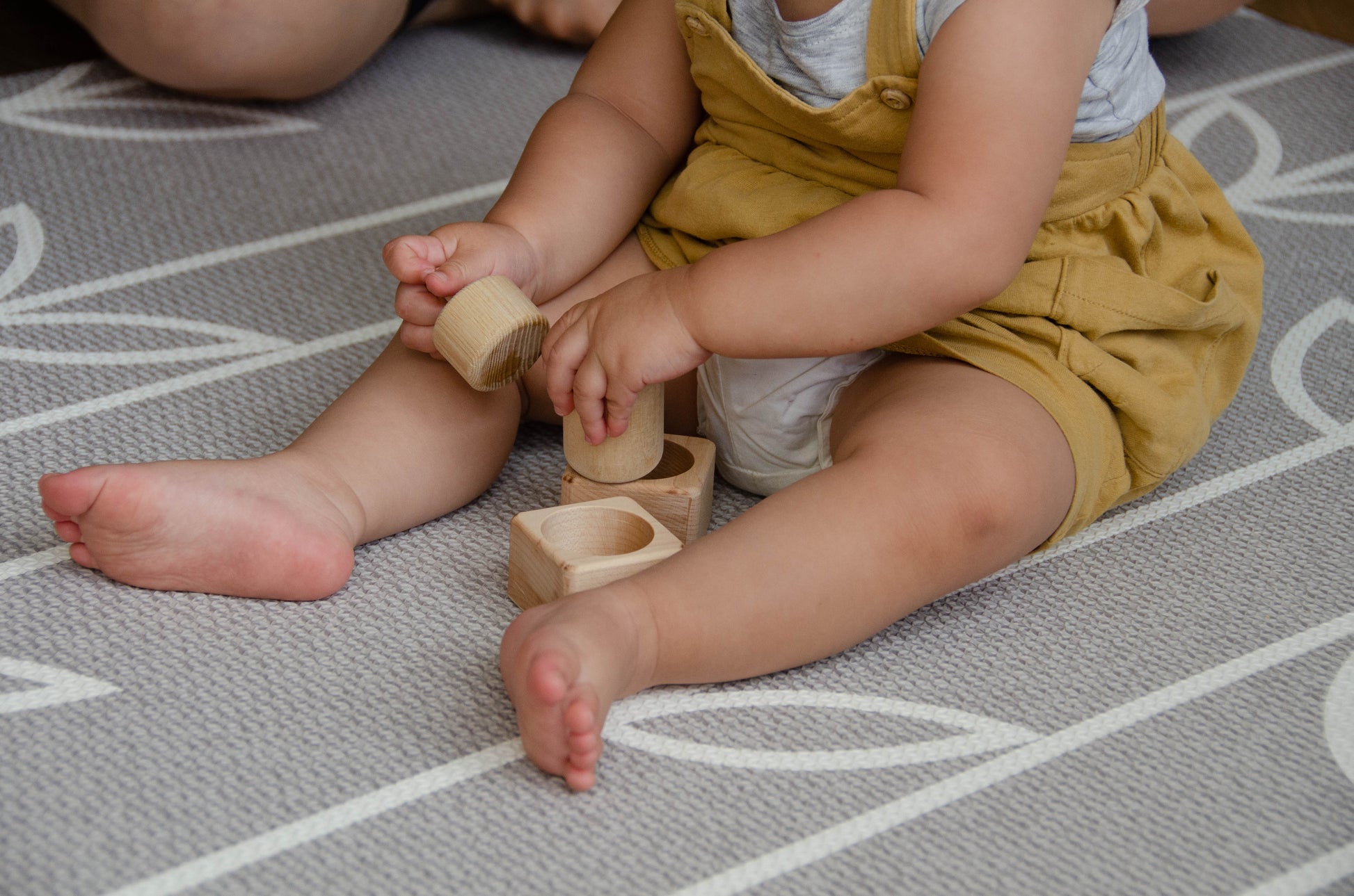 The baby girl is thoroughly enjoying her playtime with Cubos Pincer & Palmer Block. With her tiny hands, she skillfully manipulates the blocks, using the pincer grip to grasp and place them. This interactive and tactile play enhances her fine motor skills, hand-eye coordination, and cognitive development as she explores the different shapes and builds various structures. Her joyful engagement with the educational toy fosters early learning and creativity, making playtime an enriching experience for her.