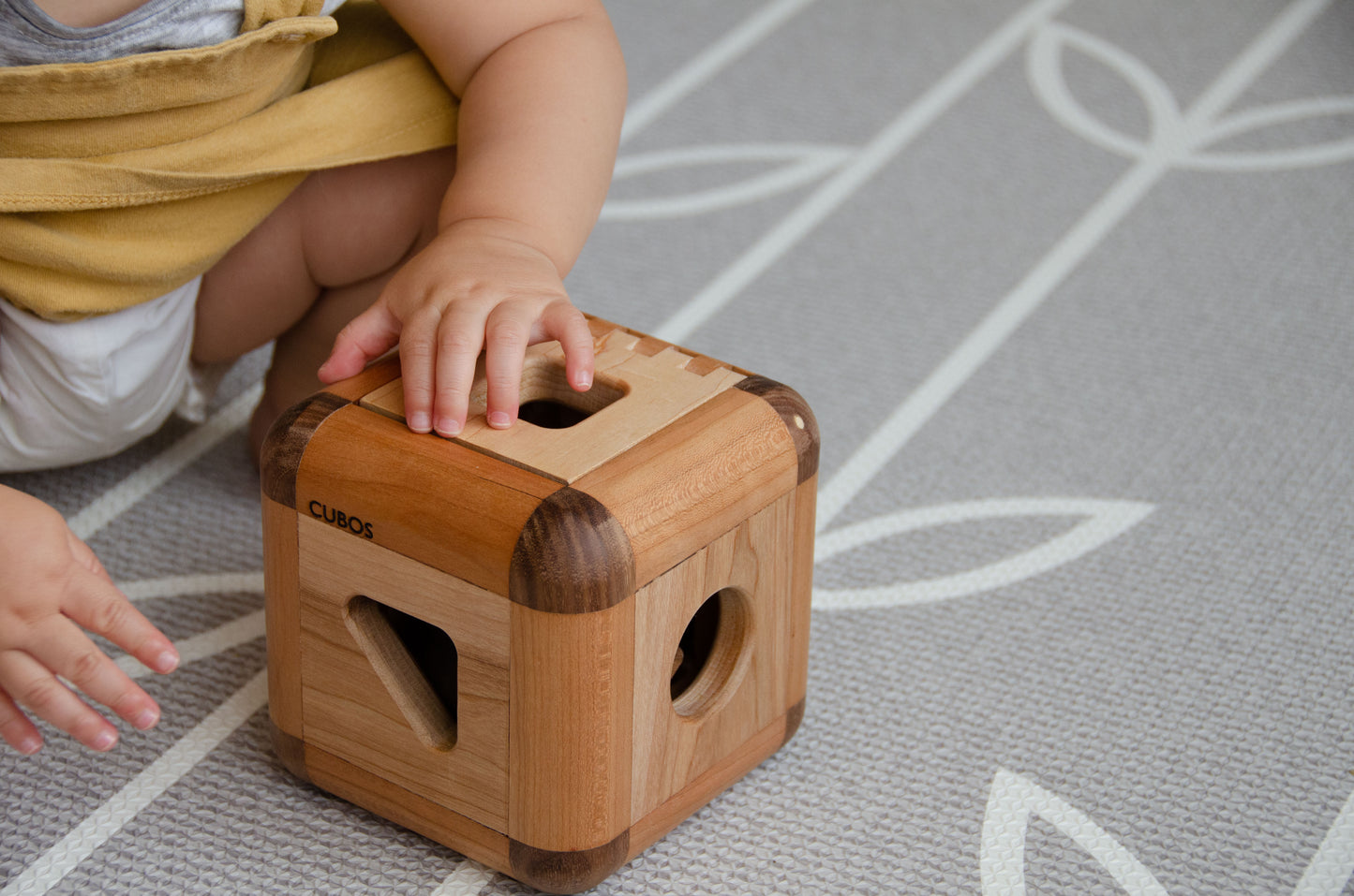 Sweet baby girl closing the lid of the Cubos Lite, completing her playtime adventure with the set and preserving its contents for the next delightful play session.