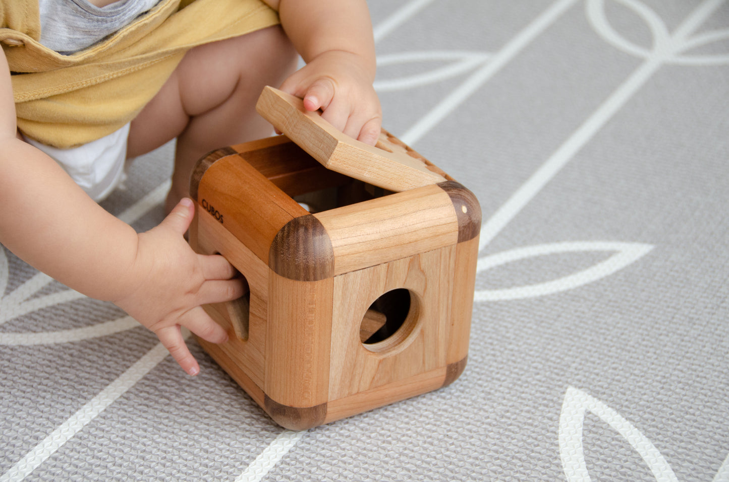 Adorable baby girl opening the Cubos Lite, discovering its contents with excitement and delight, ready to engage in joyful playtime exploration.